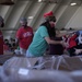 Volunteers pack donated goods into airdrop bundles during the 70th annual Operation Christmas Drop