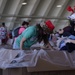 Volunteers pack donated goods into airdrop bundles during the 70th annual Operation Christmas Drop