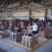 Volunteers pack donated goods into airdrop bundles during the 70th annual Operation Christmas Drop