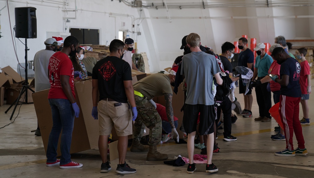 Volunteers pack donated goods into airdrop bundles during the 70th annual Operation Christmas Drop