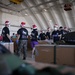 Volunteers pack donated goods into airdrop bundles during the 70th annual Operation Christmas Drop