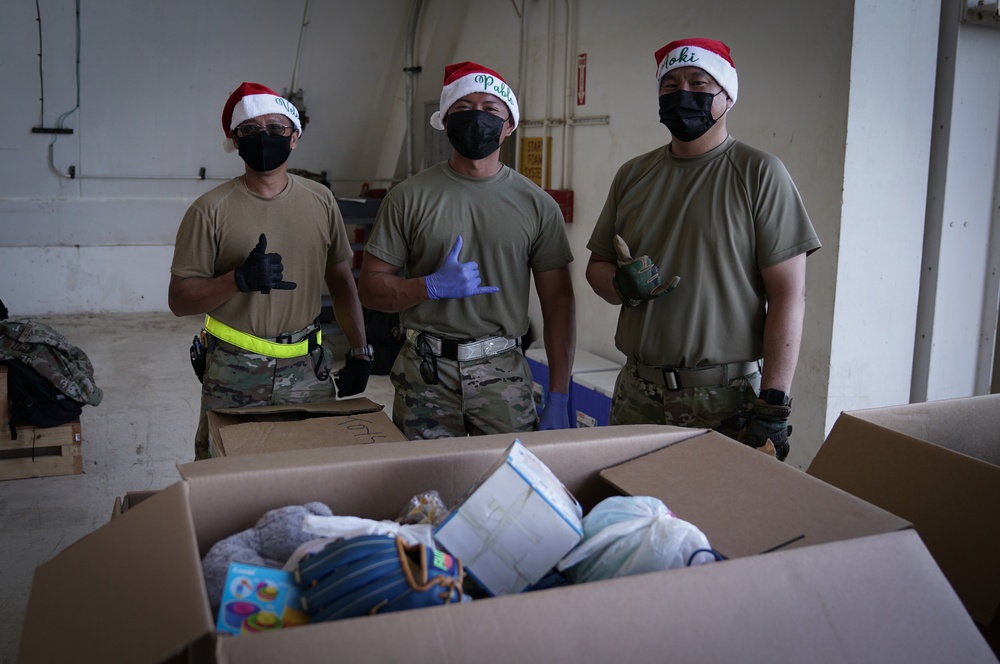 Volunteers pack donated goods into airdrop bundles during the 70th annual Operation Christmas Drop