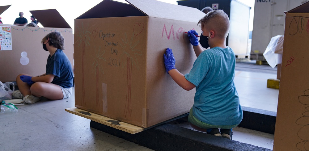 Volunteers pack donated goods into airdrop bundles during the 70th annual Operation Christmas Drop