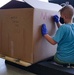 Volunteers pack donated goods into airdrop bundles during the 70th annual Operation Christmas Drop