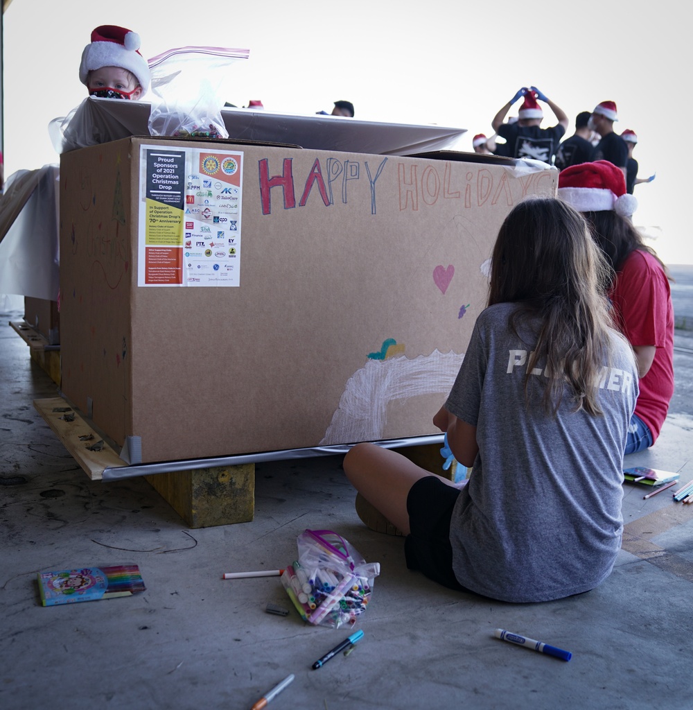 Volunteers pack donated goods into airdrop bundles during the 70th annual Operation Christmas Drop