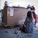 Volunteers pack donated goods into airdrop bundles during the 70th annual Operation Christmas Drop