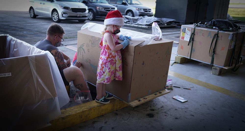 Volunteers pack donated goods into airdrop bundles during the 70th annual Operation Christmas Drop