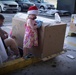 Volunteers pack donated goods into airdrop bundles during the 70th annual Operation Christmas Drop