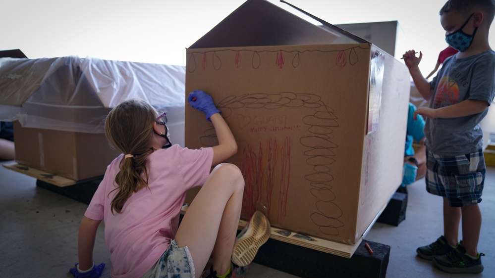 Volunteers pack donated goods into airdrop bundles during the 70th annual Operation Christmas Drop