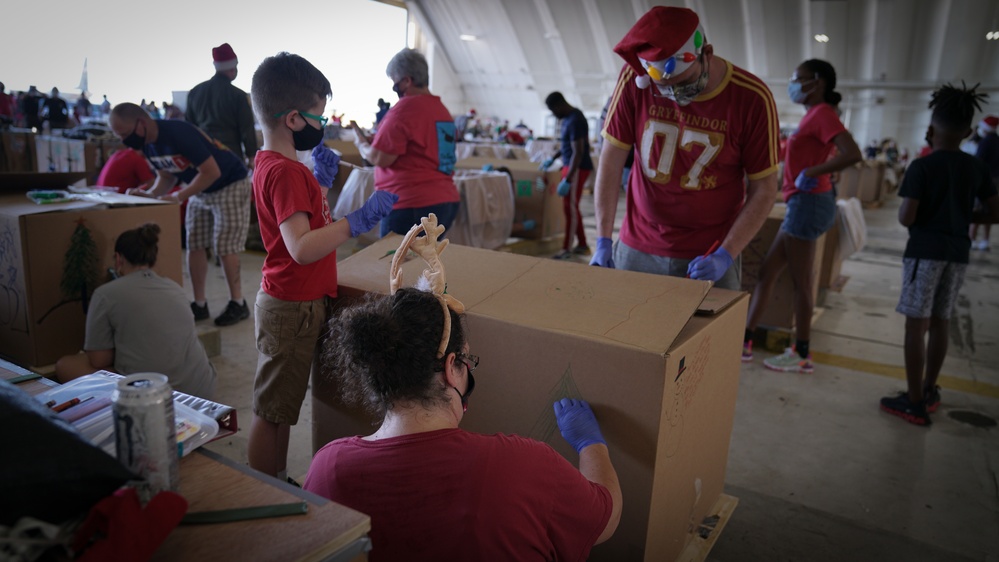 Volunteers pack donated goods into airdrop bundles during the 70th annual Operation Christmas Drop