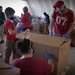 Volunteers pack donated goods into airdrop bundles during the 70th annual Operation Christmas Drop