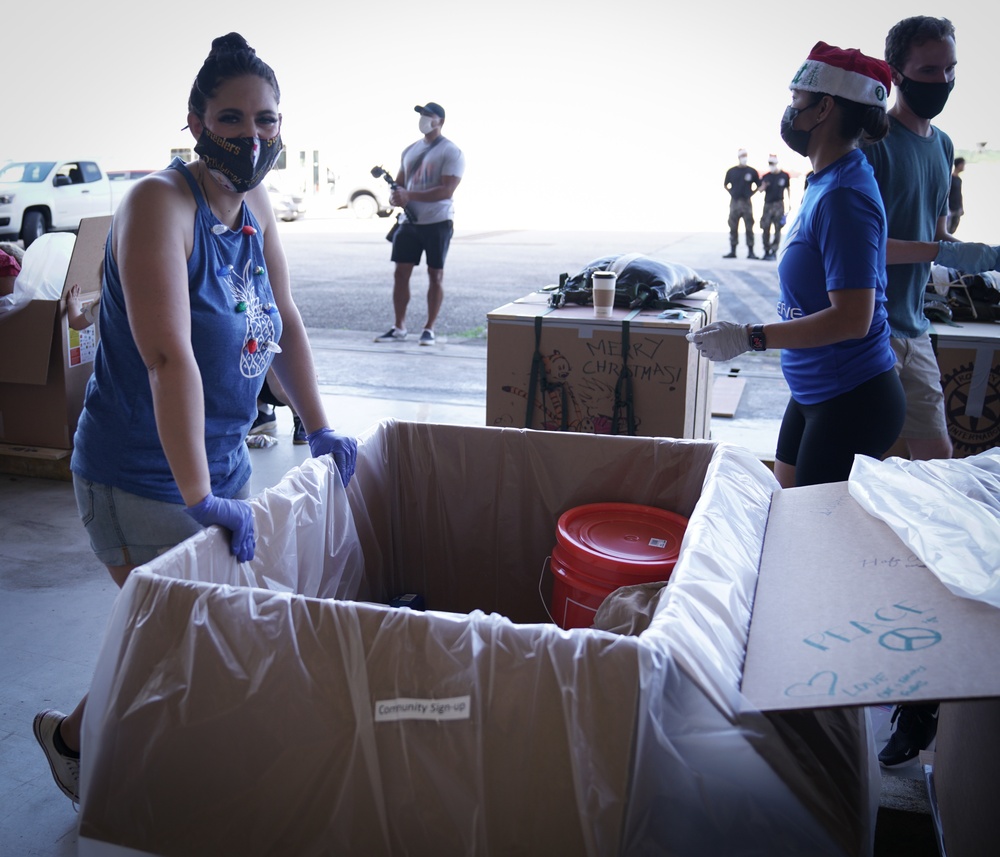 Volunteers pack donated goods into airdrop bundles during the 70th annual Operation Christmas Drop