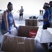 Volunteers pack donated goods into airdrop bundles during the 70th annual Operation Christmas Drop