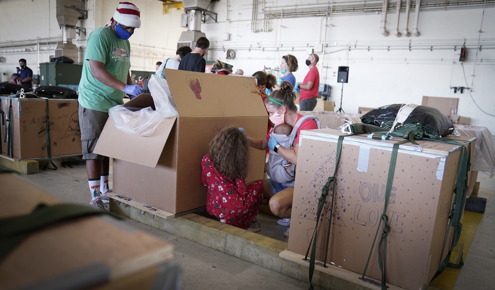 Volunteers pack donated goods into airdrop bundles during the 70th annual Operation Christmas Drop