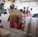 Volunteers pack donated goods into airdrop bundles during the 70th annual Operation Christmas Drop