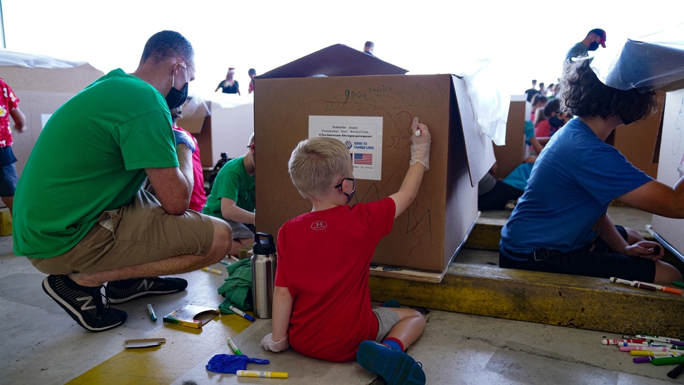 Volunteers pack donated goods into airdrop bundles during the 70th annual Operation Christmas Drop