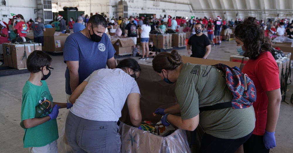 Volunteers pack donated goods into airdrop bundles during the 70th annual Operation Christmas Drop