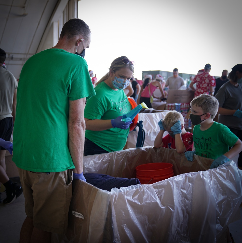 Volunteers pack donated goods into airdrop bundles during the 70th annual Operation Christmas Drop