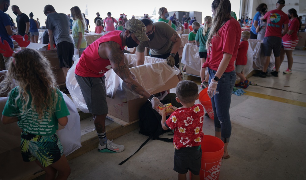 Volunteers pack donated goods into airdrop bundles during the 70th annual Operation Christmas Drop