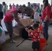 Volunteers pack donated goods into airdrop bundles during the 70th annual Operation Christmas Drop