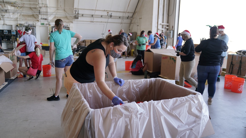 Volunteers pack donated goods into airdrop bundles during the 70th annual Operation Christmas Drop