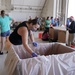 Volunteers pack donated goods into airdrop bundles during the 70th annual Operation Christmas Drop