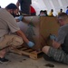 Volunteers pack donated goods into airdrop bundles during the 70th annual Operation Christmas Drop