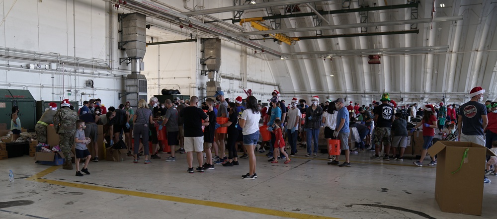 Volunteers pack donated goods into airdrop bundles during the 70th annual Operation Christmas Drop