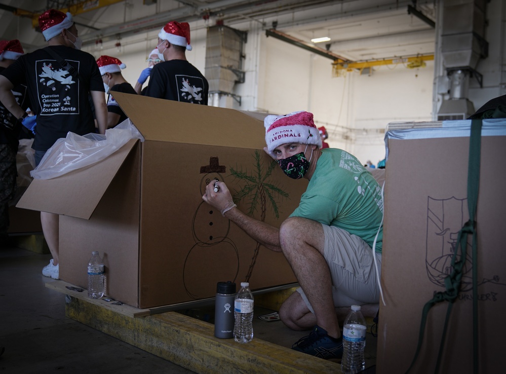 Volunteers pack donated goods into airdrop bundles during the 70th annual Operation Christmas Drop