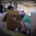 Volunteers pack donated goods into airdrop bundles during the 70th annual Operation Christmas Drop