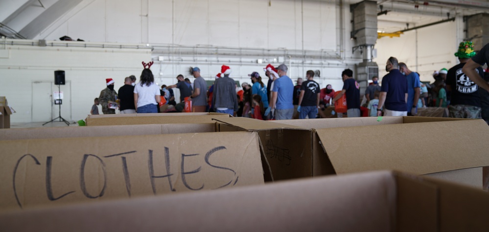 Volunteers pack donated goods into airdrop bundles during the 70th annual Operation Christmas Drop