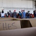 Volunteers pack donated goods into airdrop bundles during the 70th annual Operation Christmas Drop