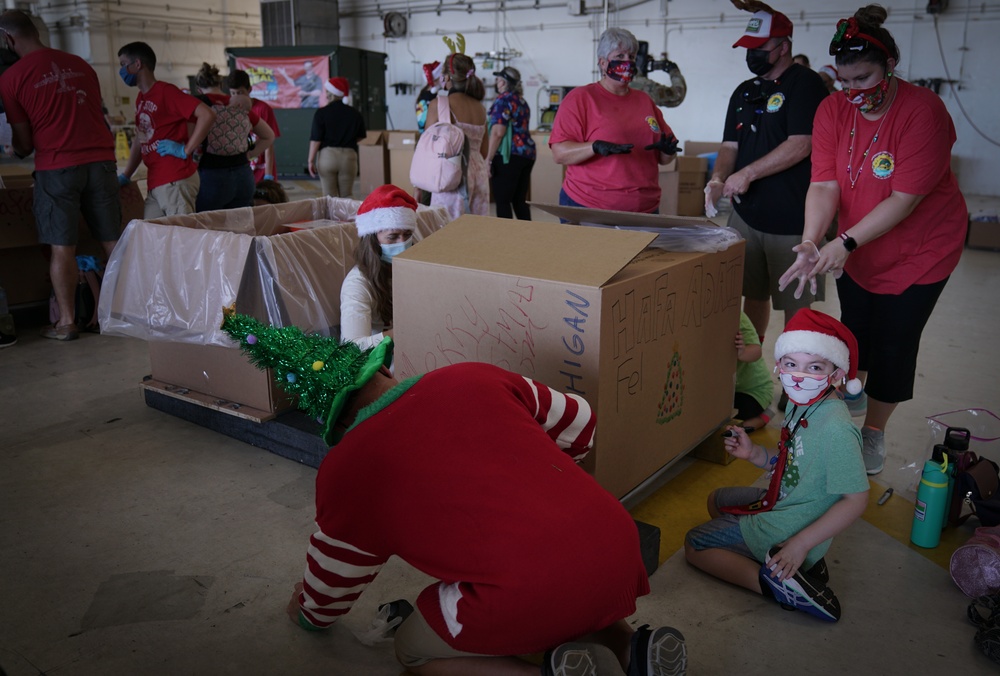 Volunteers pack donated goods into airdrop bundles during the 70th annual Operation Christmas Drop