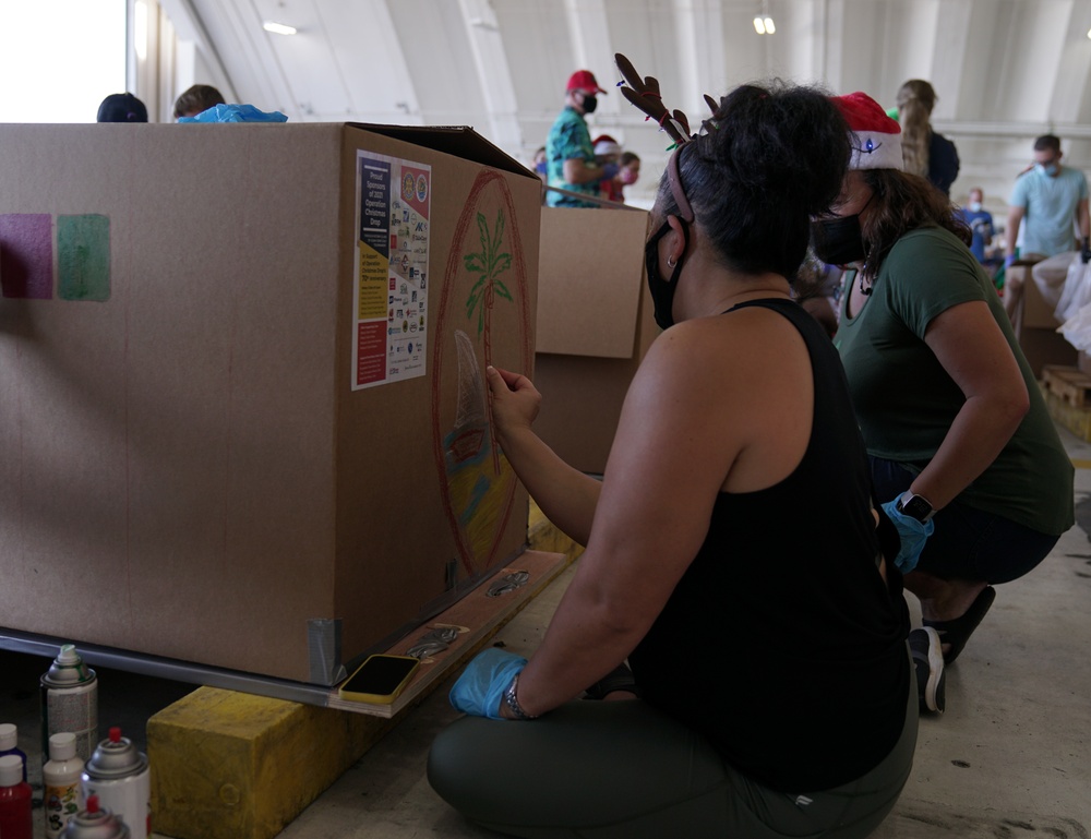 Volunteers pack donated goods into airdrop bundles during the 70th annual Operation Christmas Drop