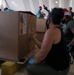 Volunteers pack donated goods into airdrop bundles during the 70th annual Operation Christmas Drop