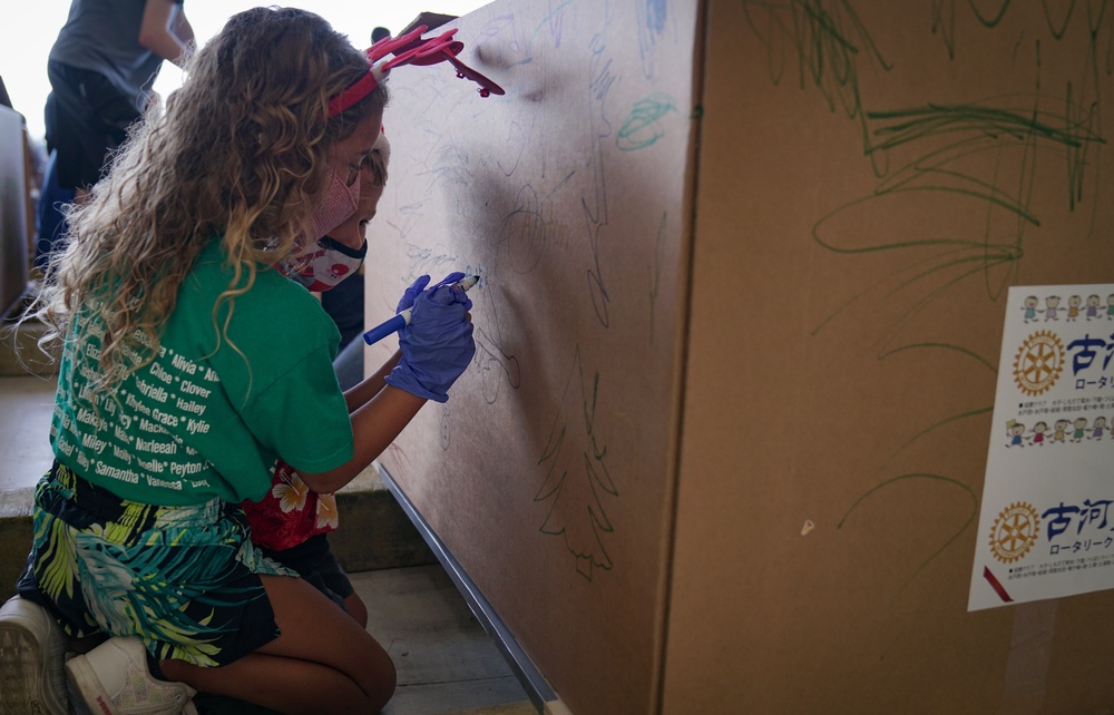 Volunteers pack donated goods into airdrop bundles during the 70th annual Operation Christmas Drop