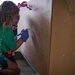 Volunteers pack donated goods into airdrop bundles during the 70th annual Operation Christmas Drop