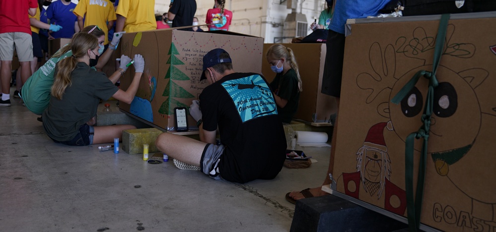 Volunteers pack donated goods into airdrop bundles during the 70th annual Operation Christmas Drop