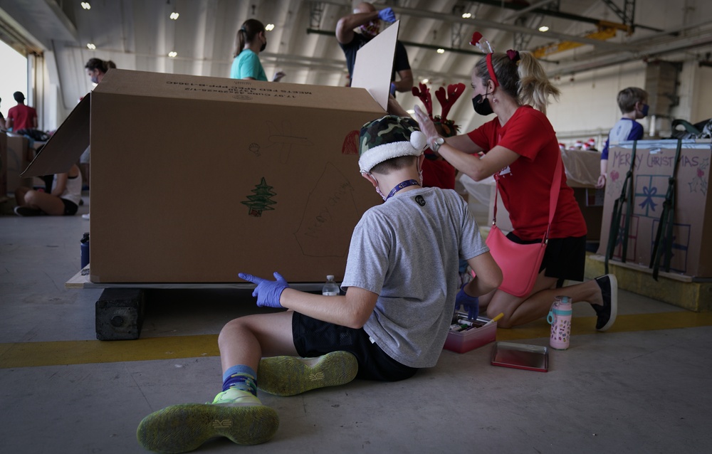 Volunteers pack donated goods into airdrop bundles during the 70th annual Operation Christmas Drop