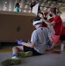 Volunteers pack donated goods into airdrop bundles during the 70th annual Operation Christmas Drop