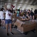 Volunteers pack donated goods into airdrop bundles during the 70th annual Operation Christmas Drop