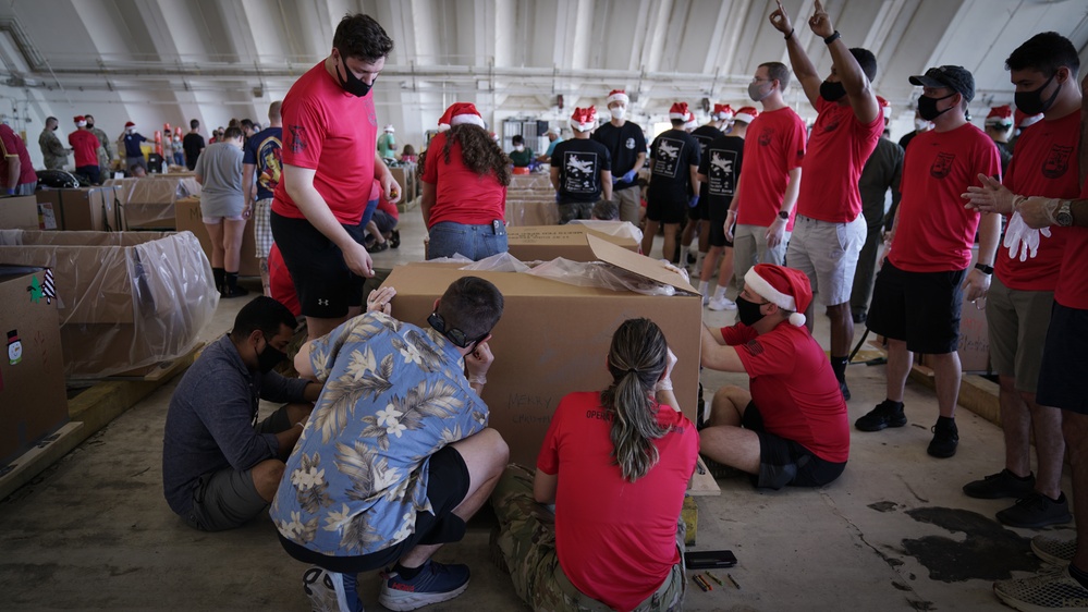 Volunteers pack donated goods into airdrop bundles during the 70th annual Operation Christmas Drop