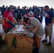 Volunteers pack donated goods into airdrop bundles during the 70th annual Operation Christmas Drop