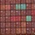The image shows a densely packed wall of intermodal shipping containers stacked multiple rows high on what appears to be a cargo vessel. The containers are predominantly dark red/maroon in color, with a few teal/green and blue containers providing visual contrast. Multiple shipping company markings are visible, most notably 'ZIM' and 'CAI' and 'tex' branding.
