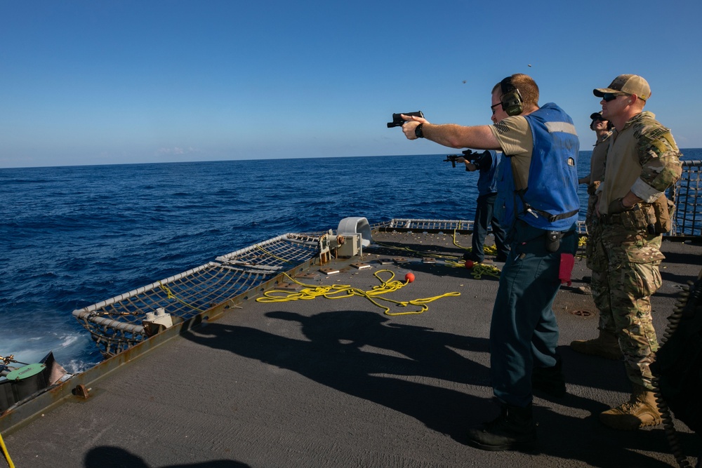 USS Sioux City Sailor Fires Gun During a Live-Fire Exercise
