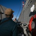 USS Sioux City Sailor Hoists Flag During Outbound Sea and Anchor Detail