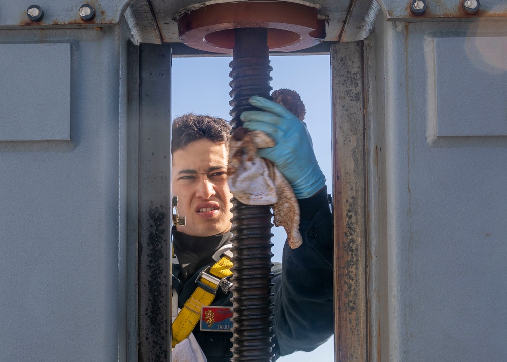 Sailor Performs Maintenance on Sliding Padeye