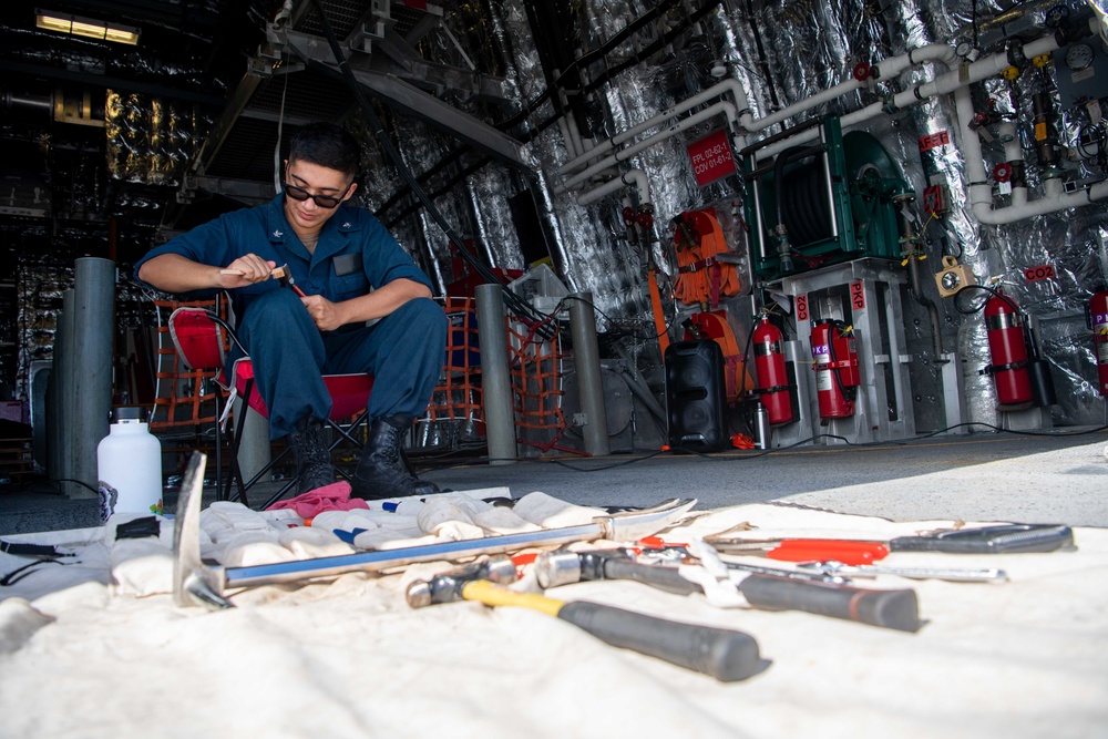 USS Charleston Sailor Conducts Maintenance on Equipment