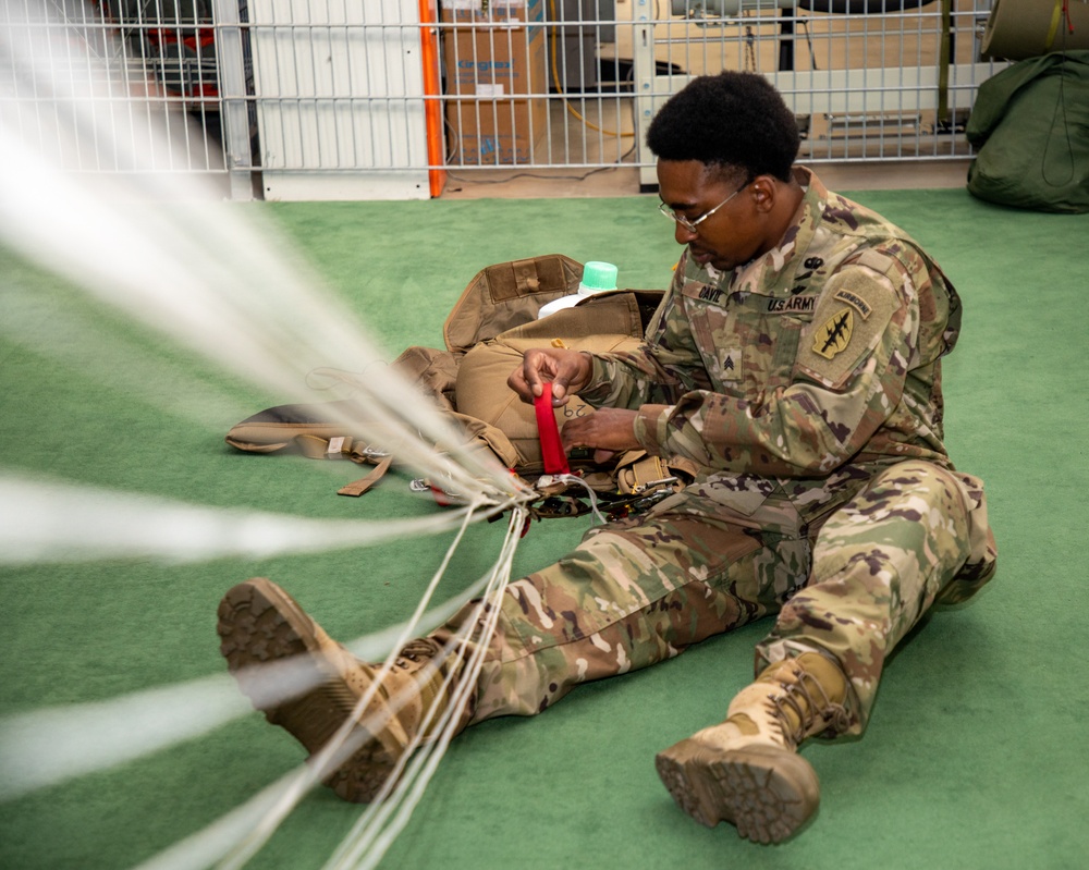 10th SFG riggers pack and inspect parachutes