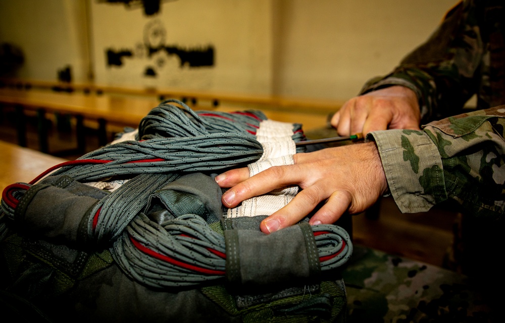 10th SFG riggers pack and inspect parachutes